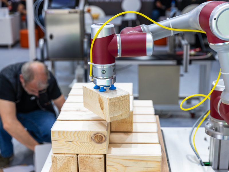 Collaborative,Industrial,Robot,Arm,Operating,Alongside,Blurred,Human,Worker,While