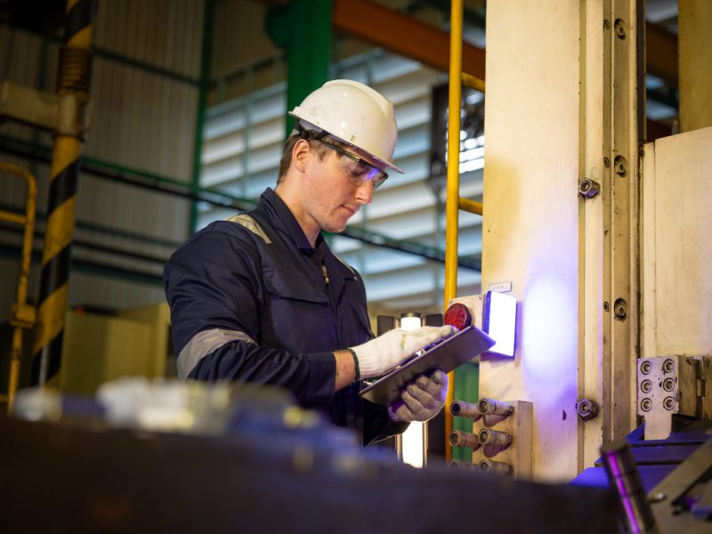 Male,Factory,Worker,Holding,Digital,Tablet,Checking,Manufacturing,Machine,With