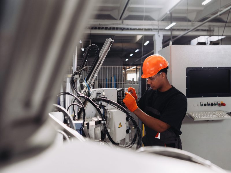 Young,Engineer,Performing,Maintenance,On,A,Production,Line,Machine,In