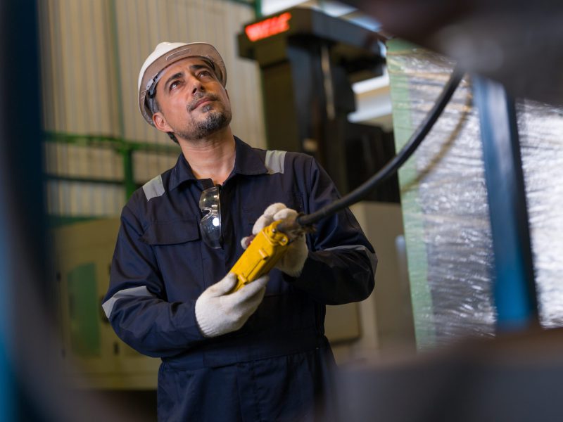 Professional,Male,Engineer,Wearing,Safety,Uniform,Operating,Remote,Control,Pendant